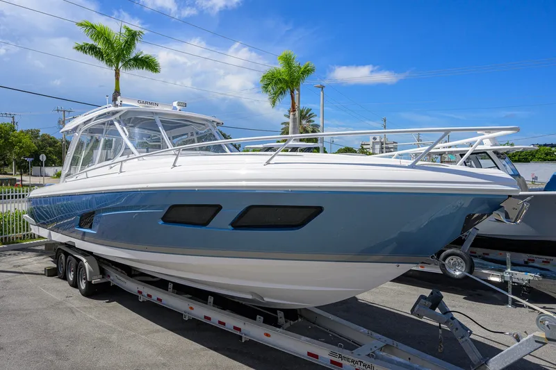 Slide: The Image of 2022 Intrepid 409 Valor boat on trailer, sleek design, blue and white exterior. - 4