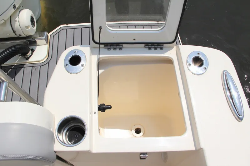 Slide: The Image of Open storage compartment on 2022 Scout 240 Dorado boat deck with cup holders. - 18