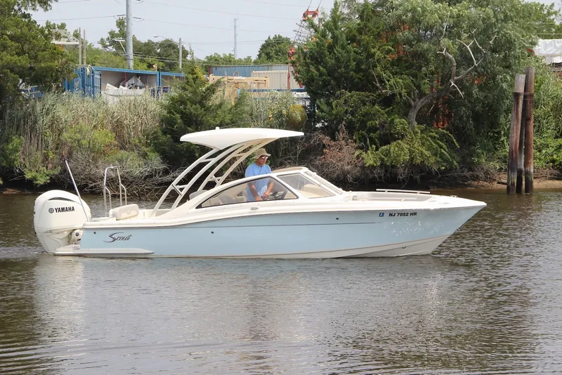 The Image of 2022 Scout 240 Dorado boat cruising on a calm river with lush greenery. - 0
