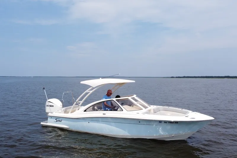 Slide: The Image of 2022 Scout 240 Dorado boat cruising on open water under clear skies. - 5