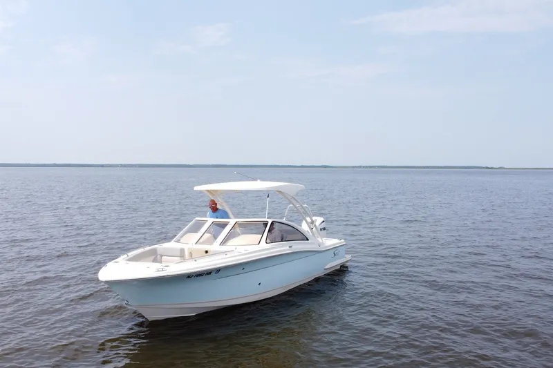 Slide: The Image of 2022 Scout 240 Dorado boat cruising on calm waters under a clear sky. - 4