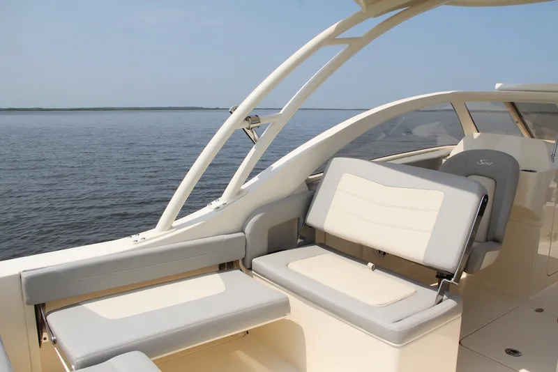 Slide: The Image of 2022 Scout 240 Dorado boat interior with comfortable seating on calm water. - 12