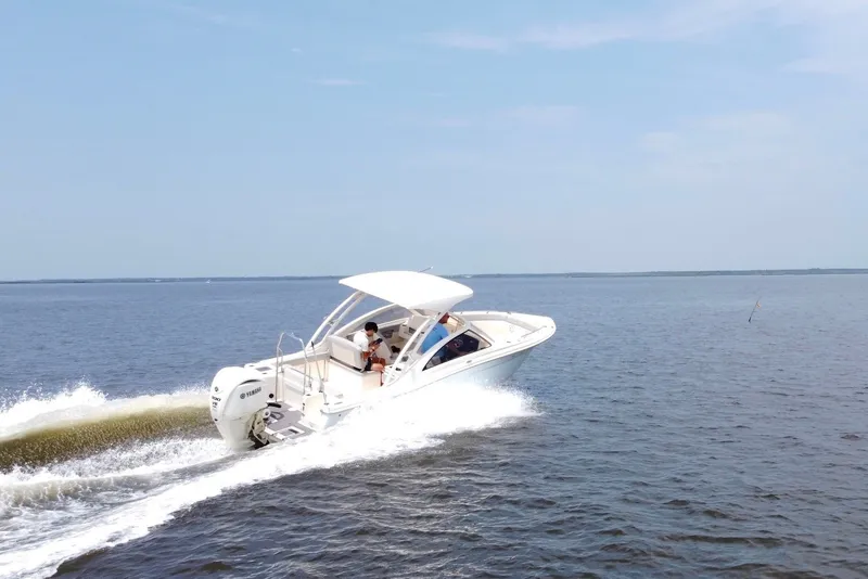 Slide: The Image of 2022 Scout 240 Dorado boat cruising on open water under clear skies. - 7