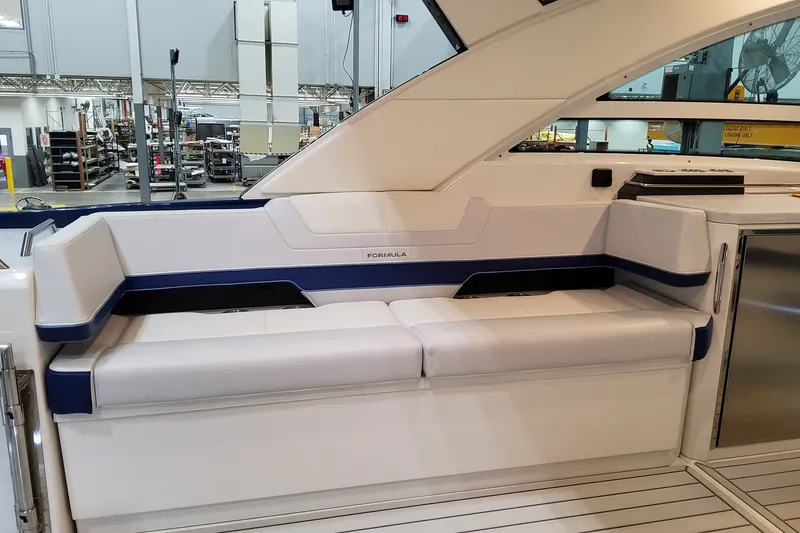 Slide: The Image of 2027 Formula 430 Super Sport Crossover interior seating in a modern boat showroom. - 23