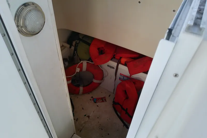 Slide: The Image of Storage area on 2004 Stamas 310 Tarpon boat with life jackets and safety equipment. - 58