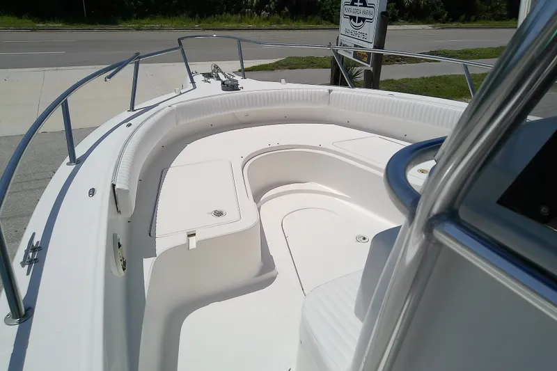 Slide: The Image of 2004 Stamas 310 Tarpon boat deck with seating and railing, docked near a road. - 27