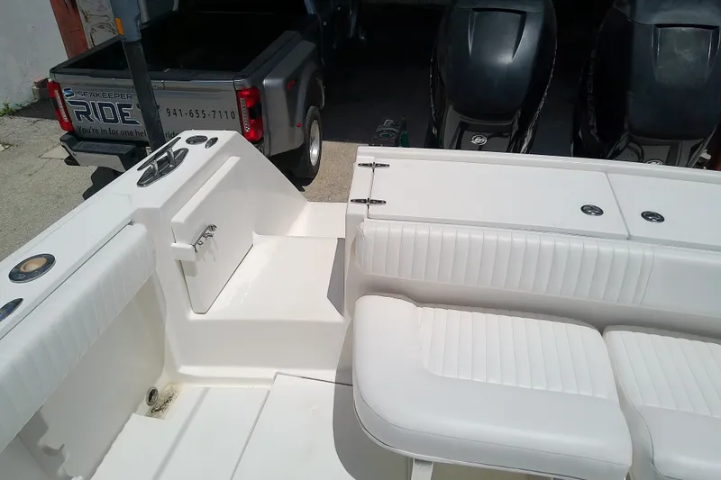 Slide: The Image of 2004 Stamas 310 Tarpon boat interior with white seating and dual outboard motors. - 16