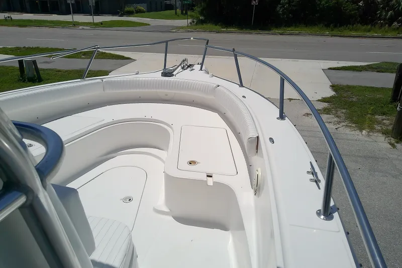 Slide: The Image of 2004 Stamas 310 Tarpon boat deck with seating and storage, parked near a road. - 26