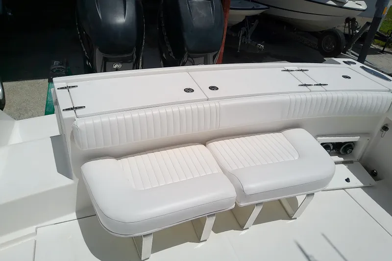 Slide: The Image of 2004 Stamas 310 Tarpon boat interior with white cushioned seating and dual engines. - 18