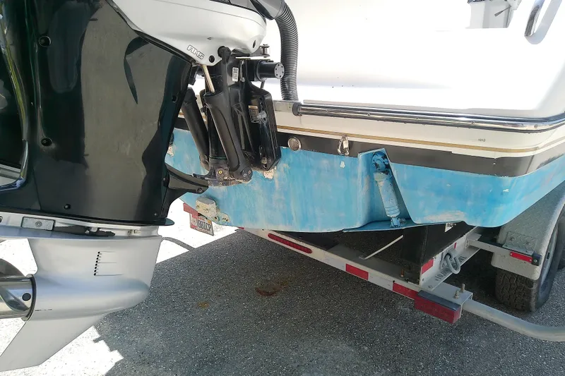 Slide: The Image of 2004 Stamas 310 Tarpon boat on trailer, showing outboard motor and blue hull. - 13