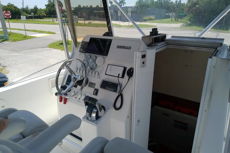 Slide: The Image of 2004 Stamas 310 Tarpon boat cockpit with steering wheel and navigation equipment. - 21