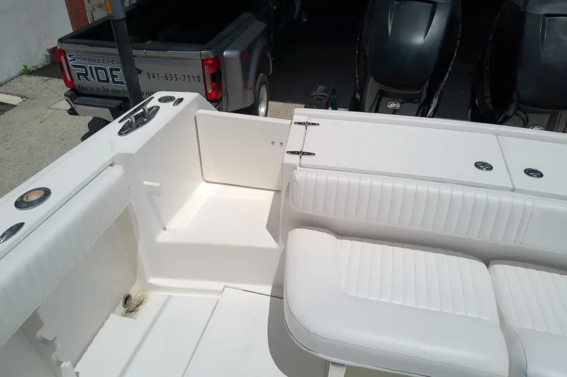 Slide: The Image of 2004 Stamas 310 Tarpon boat interior with white seating and storage compartments. - 17