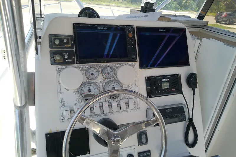 Slide: The Image of 2004 Stamas 310 Tarpon boat dashboard with Simrad electronics and steering wheel. - 45