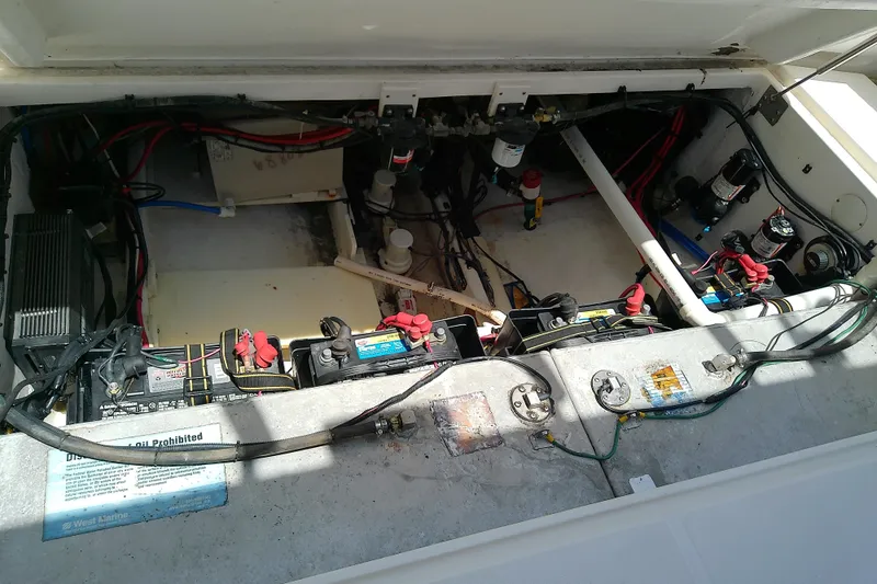 Slide: The Image of Open engine compartment of a 2004 Stamas 310 Tarpon boat, showing batteries and wiring. - 51