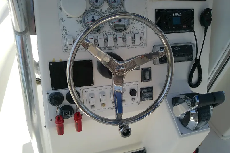 Slide: The Image of Control panel of a 2004 Stamas 310 Tarpon boat with steering wheel and gauges. - 46
