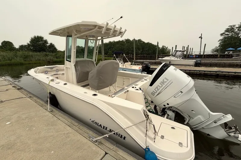 The Image of 2026 Sailfish 232 CC boat docked with Suzuki outboard motor. - 0
