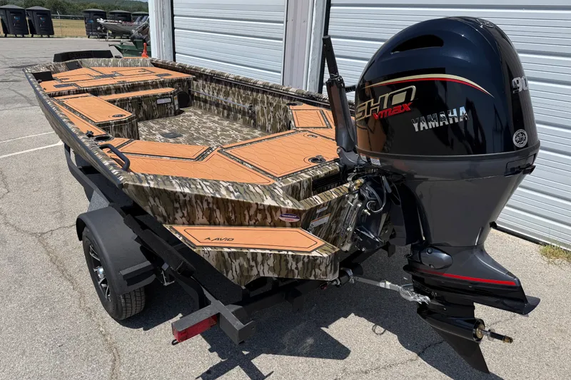 The Image of 2027 Avid 18 Commander boat with Yamaha engine, camo design, parked on trailer. - 1
