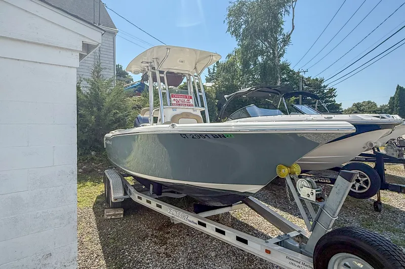 The Image of 2019 Key West 203 FS boat on trailer, parked outdoors near a building. - 1