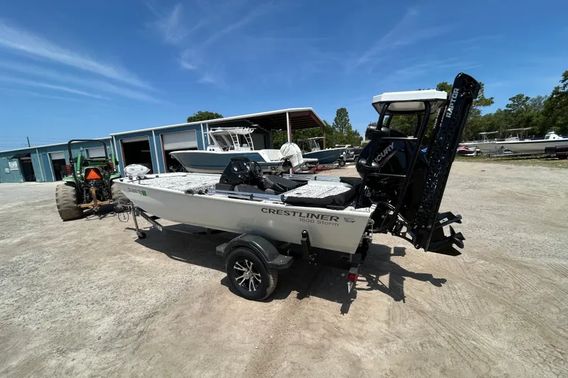 Slide: The Image of 2023 Crestliner 1600 Storm boat on trailer, parked outdoors near storage facility. - 1