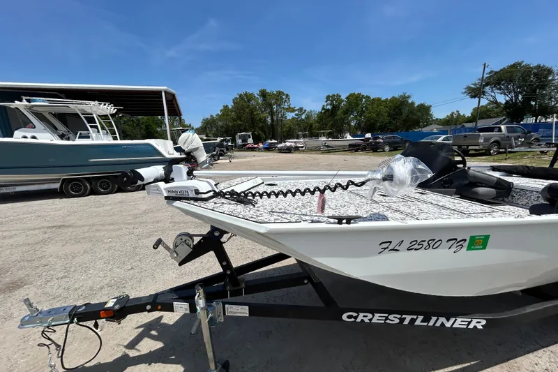 Slide: The Image of 2023 Crestliner 1600 Storm boat on trailer, parked outdoors under clear blue sky. - 2