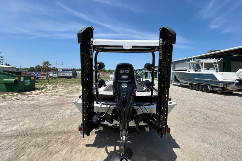 Slide: The Image of 2023 Crestliner 1600 Storm boat with powerful outboard motor, parked outdoors under clear blue sky. - 4