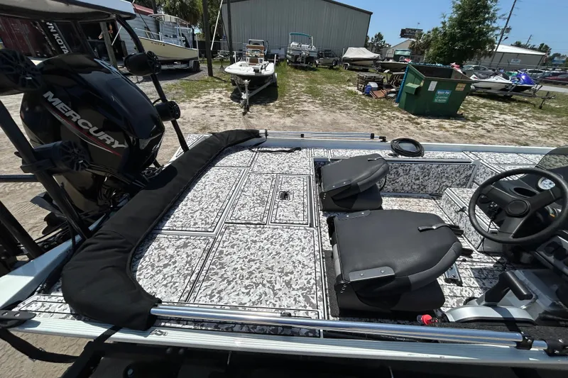 Slide: The Image of 2023 Crestliner 1600 Storm boat interior with Mercury engine, featuring patterned flooring and seating. - 11