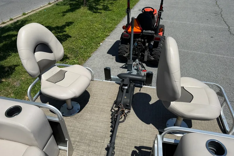 Slide: The Image of 2018 Qwest 7516 SC boat interior with beige seats and a towing tractor. - 4