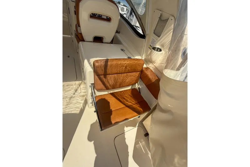 Slide: The Image of Interior of 2018 Scout 275 Dorado boat with tan leather seating and white accents. - 18