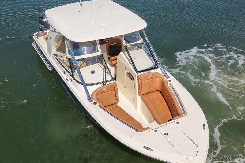 Slide: The Image of 2018 Scout 275 Dorado boat on water, featuring sleek design and spacious seating. - 10