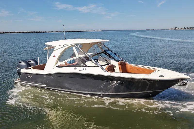 Slide: The Image of 2018 Scout 275 Dorado boat cruising on open water under clear skies. - 5