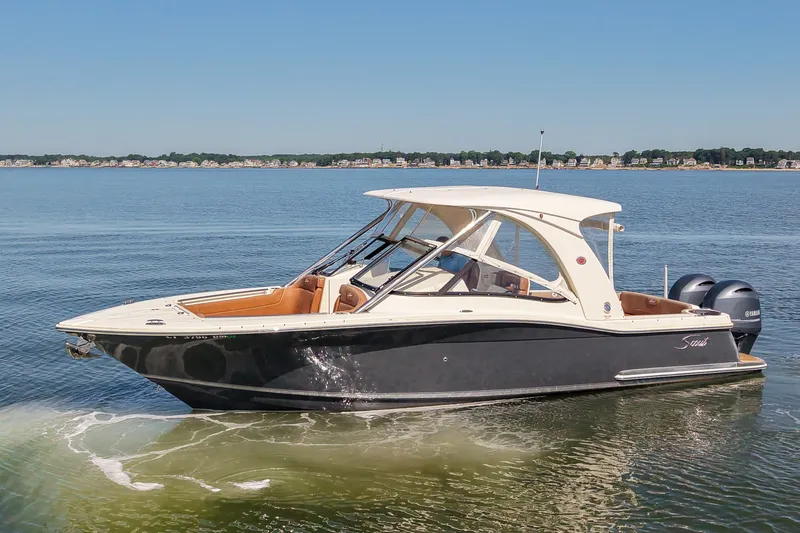 The Image of 2018 Scout 275 Dorado boat on calm water under clear blue sky. - 1