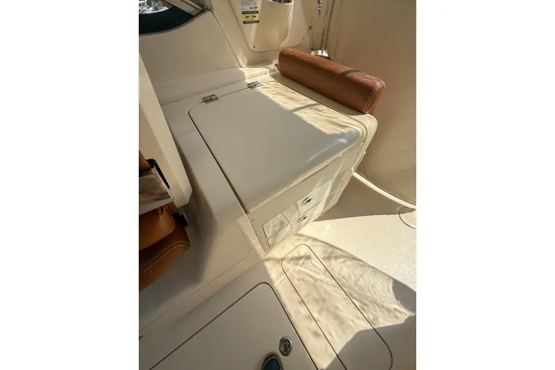 Slide: The Image of 2018 Scout 275 Dorado boat interior with storage compartment and cushioned seating. - 27