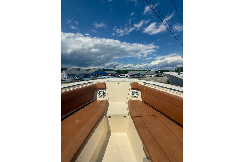 Slide: The Image of 2018 Scout 275 Dorado boat interior with brown seating under a blue sky. - 31