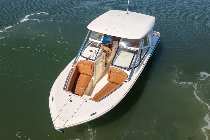 Slide: The Image of 2018 Scout 275 Dorado boat cruising on calm water, featuring sleek design and spacious seating. - 11