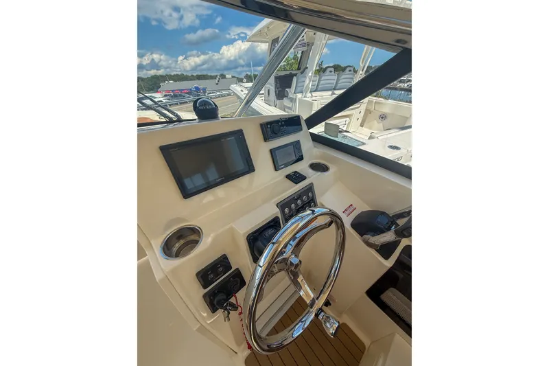 Slide: The Image of Helm of 2018 Scout 275 Dorado boat with steering wheel and navigation screens. - 23