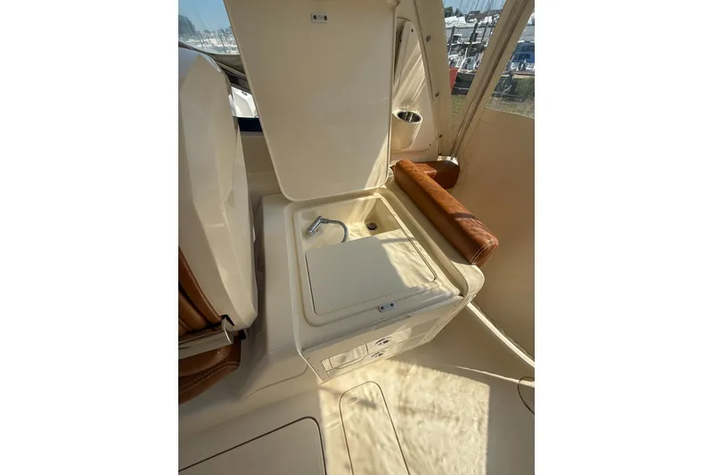 Slide: The Image of 2018 Scout 275 Dorado boat interior with open storage compartment and sink. - 28