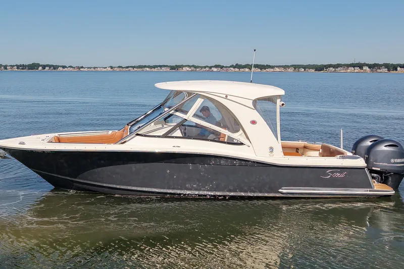 Slide: The Image of 2018 Scout 275 Dorado boat on calm water with dual Yamaha engines. - 2