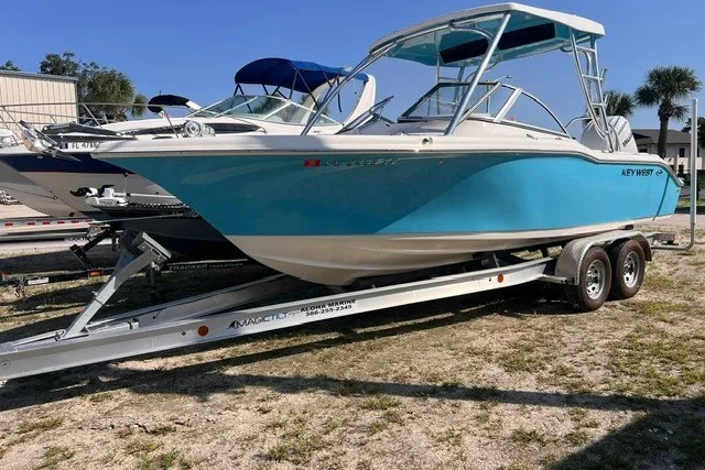 The Image of 2025 Key West 239 DFS boat on trailer, featuring sleek blue design and dual console layout. - 0