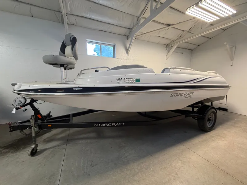 Slide: The Image of A white 2015 Starcraft 220 STARSTEP boat on a trailer in a garage. - 1