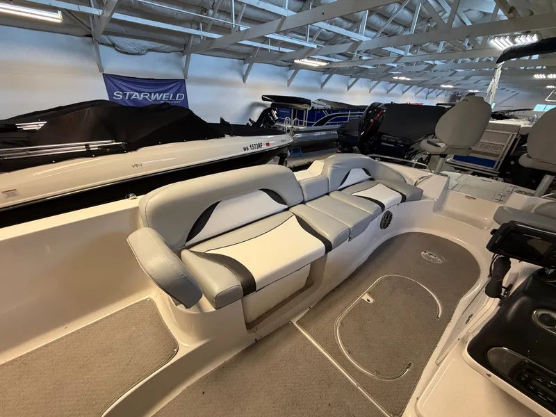 Slide: The Image of The image shows the interior of a 2015 Starcraft 220 STARSTEP boat with gray and white seating. - 28