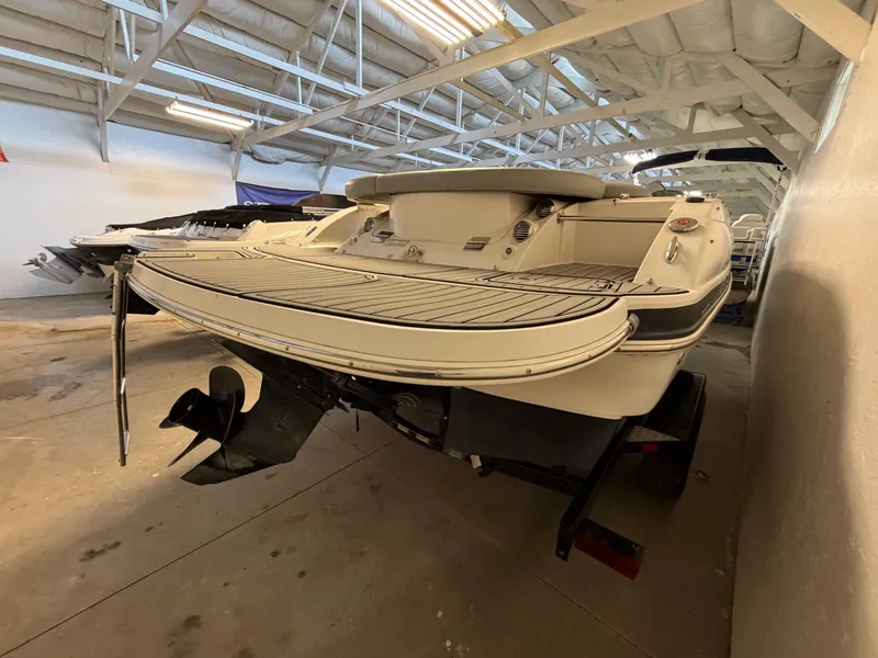 Slide: The Image of A 2015 Starcraft 220 STARSTEP boat in a storage facility. It features a large rear deck. - 12