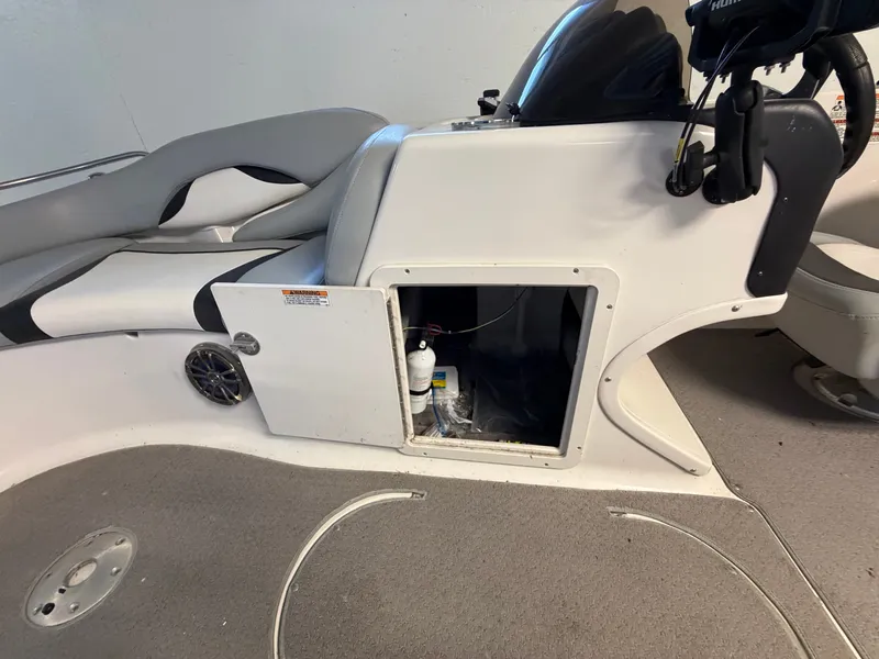 Slide: The Image of The image shows the helm of a 2015 Starcraft 220 STARSTEP boat with gray seating. - 24