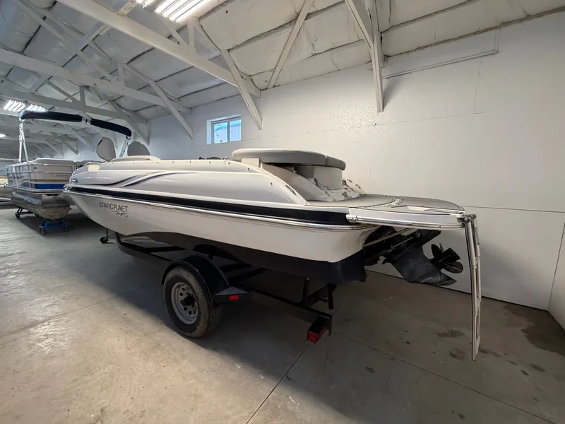 Slide: The Image of A 2015 Starcraft 220 STARSTEP boat on a trailer inside a warehouse. - 2