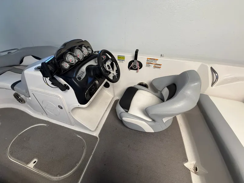 Slide: The Image of The image shows the cockpit of a 2015 Starcraft 220 STARSTEP with a helm and gray seat. - 34