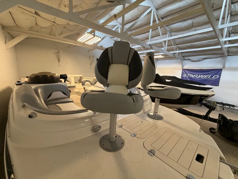 Slide: The Image of A 2015 Starcraft 220 STARSTEP boat in a storage facility with gray and white seating. - 5