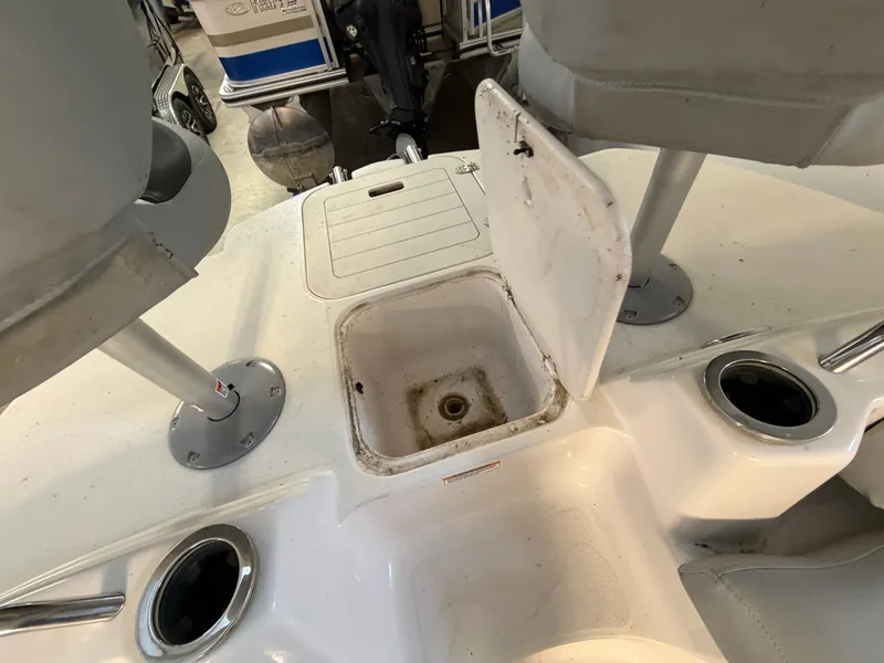 Slide: The Image of The image shows the interior of a 2015 Starcraft 220 STARSTEP boat with an open storage compartment. - 26