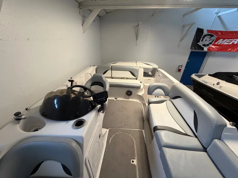 Slide: The Image of The image shows the interior of a 2015 Starcraft 220 STARSTEP boat with gray seating. - 32