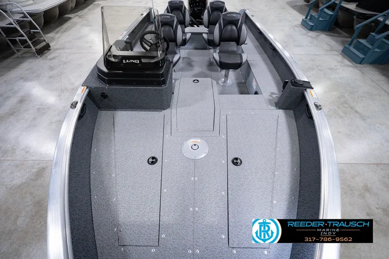 Slide: The Image of 2026 Lund 1800 Explorer SS boat interior with seating and console, displayed in showroom. - 21