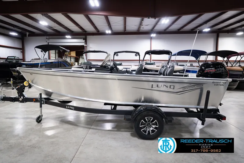 Slide: The Image of 2026 Lund 1800 Explorer SS boat in showroom, silver exterior, on trailer. - 10
