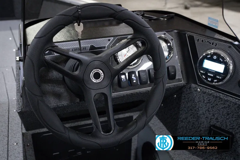 Slide: The Image of Steering wheel and dashboard of 2026 Lund 1800 Explorer SS boat, featuring modern controls. - 36